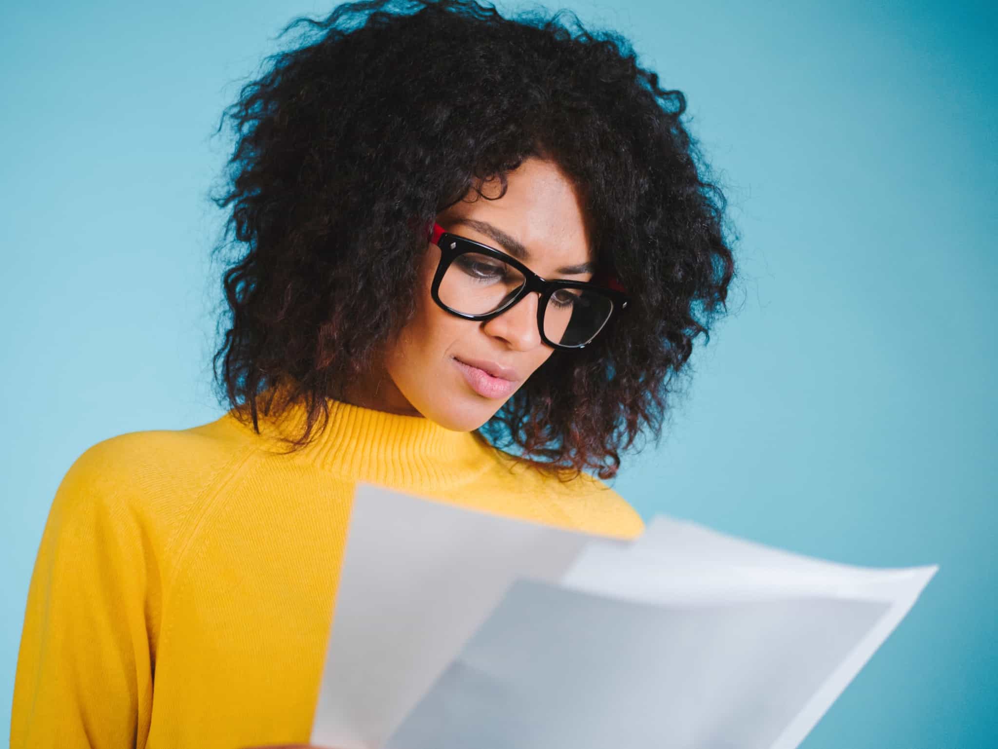 young woman consults paper documents, including proof of address